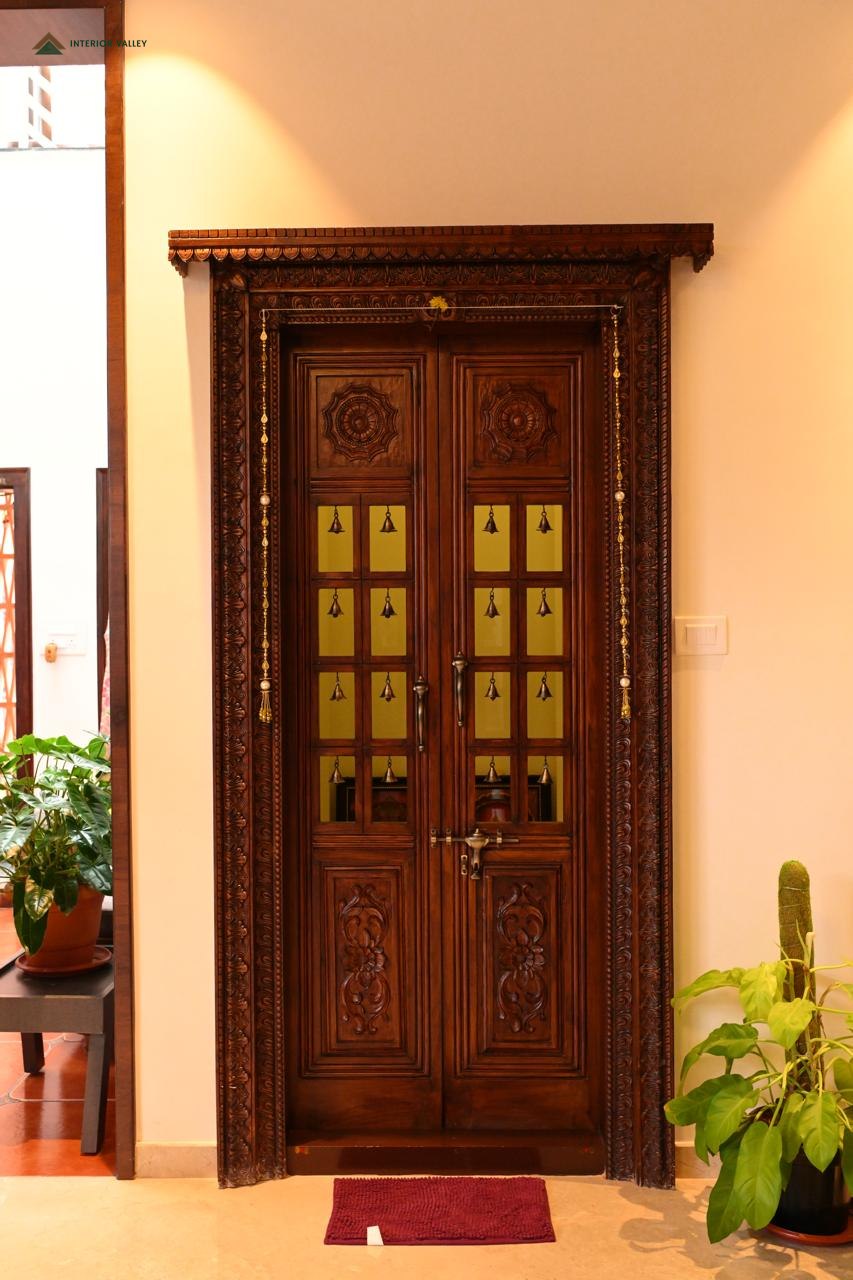 Carved teak main door at the entrance to a home