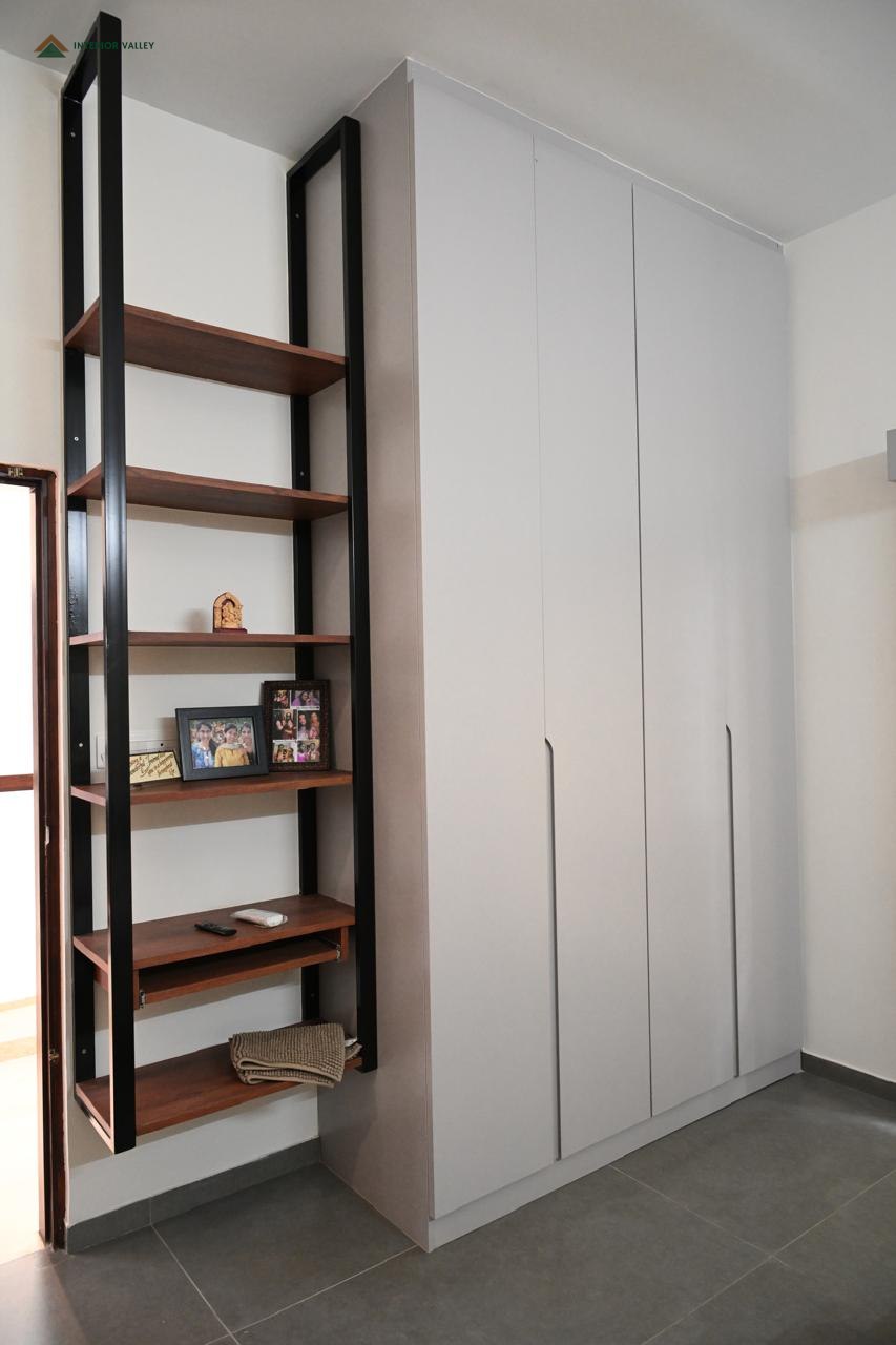 Wardrobe with a slim black metal open shelving unit alongside