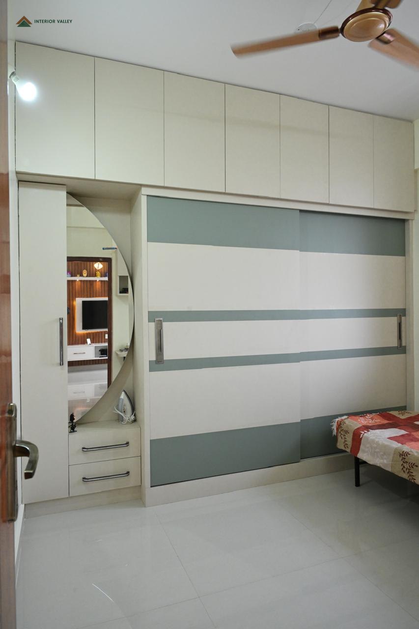 Bedroom wardrobe in white with a curved mirror panel