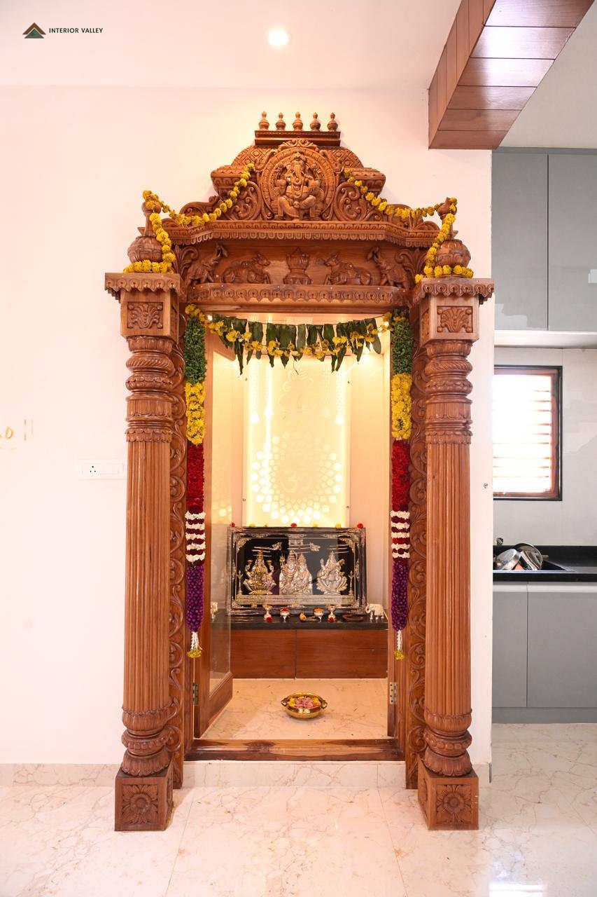 Carved teak pooja unit set into a niche