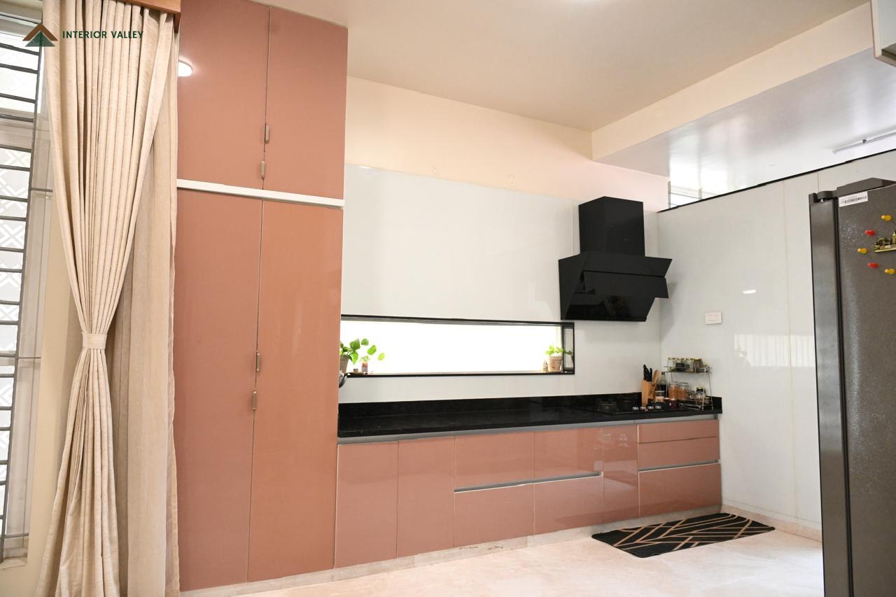 Modular kitchen in blush cabinetry with a dark counter