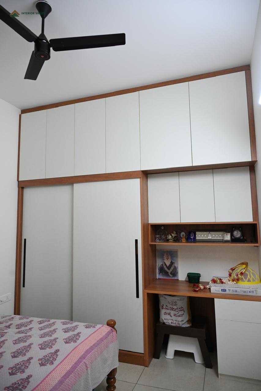Bedroom with a white wardrobe and a built-in study desk