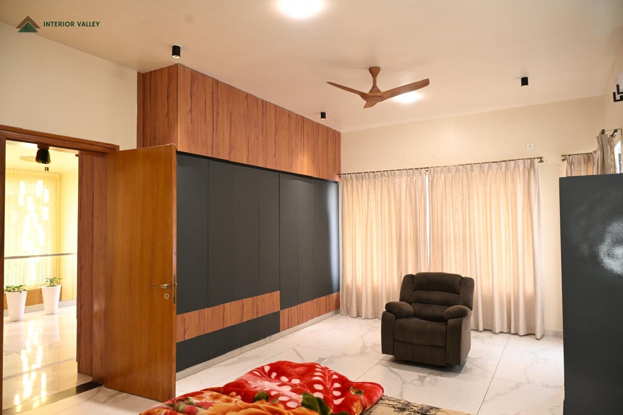 Bedroom with a wardrobe in grey and wood and a recliner