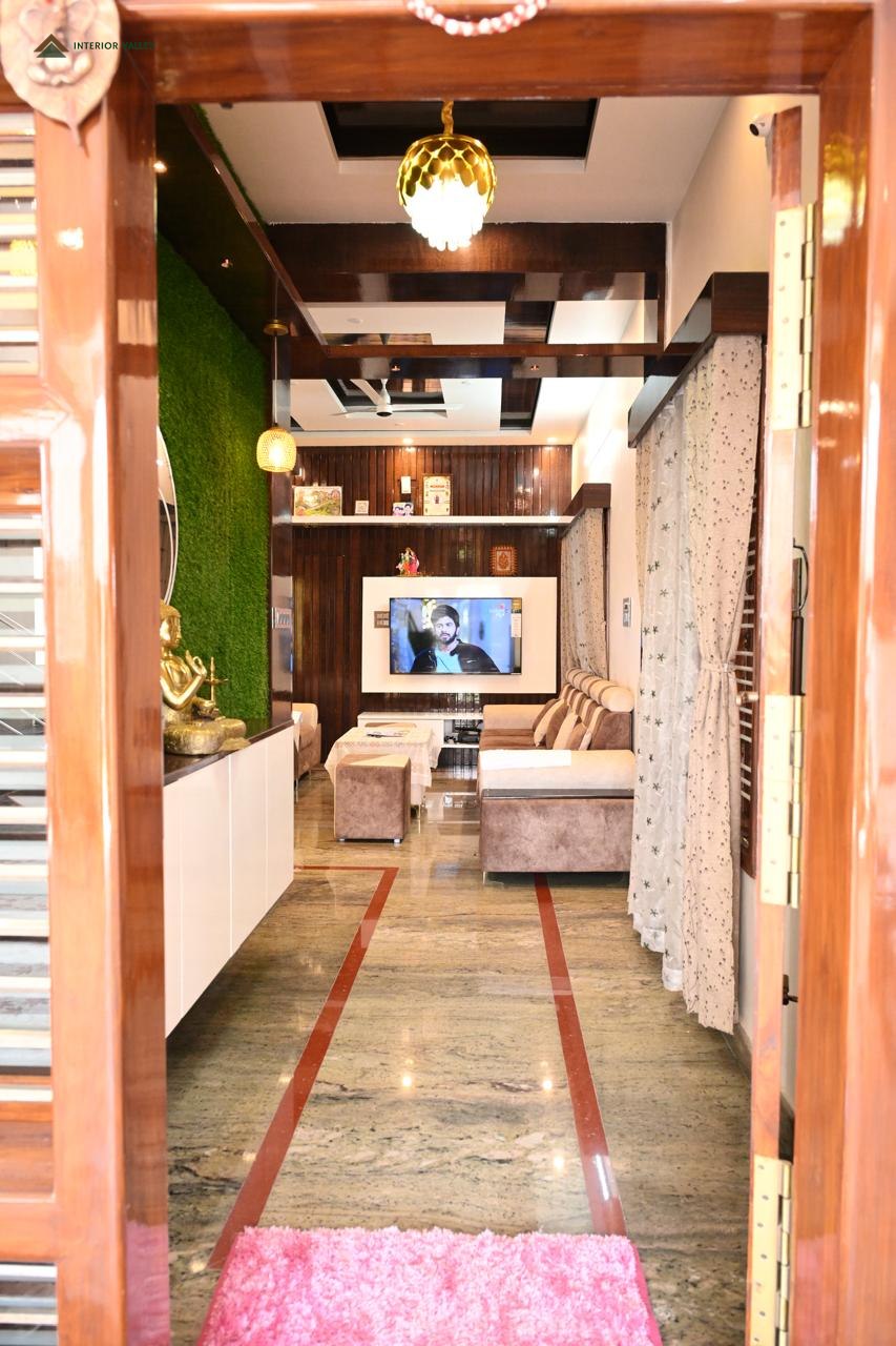 Corridor looking through to a living room with a moss feature wall