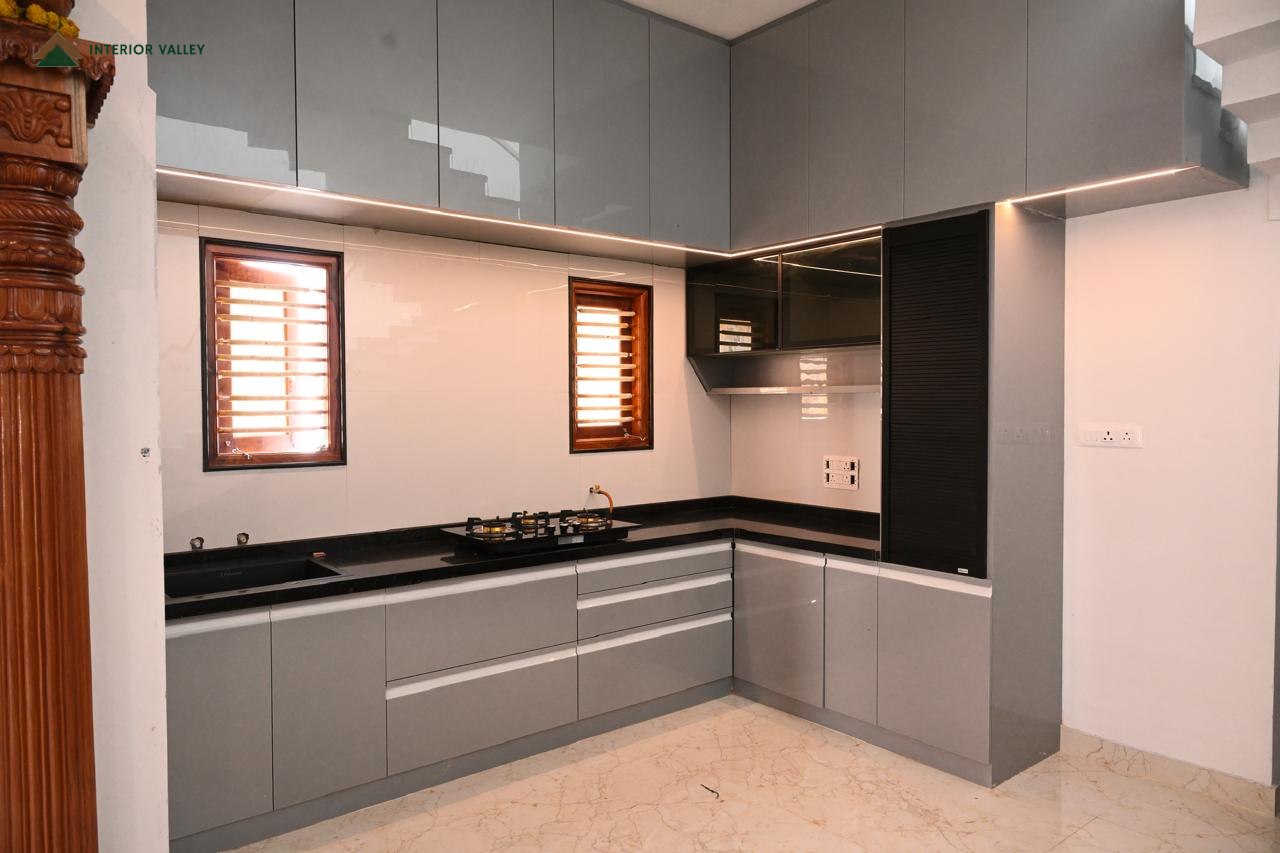 L-shaped modular kitchen in grey gloss with a granite counter