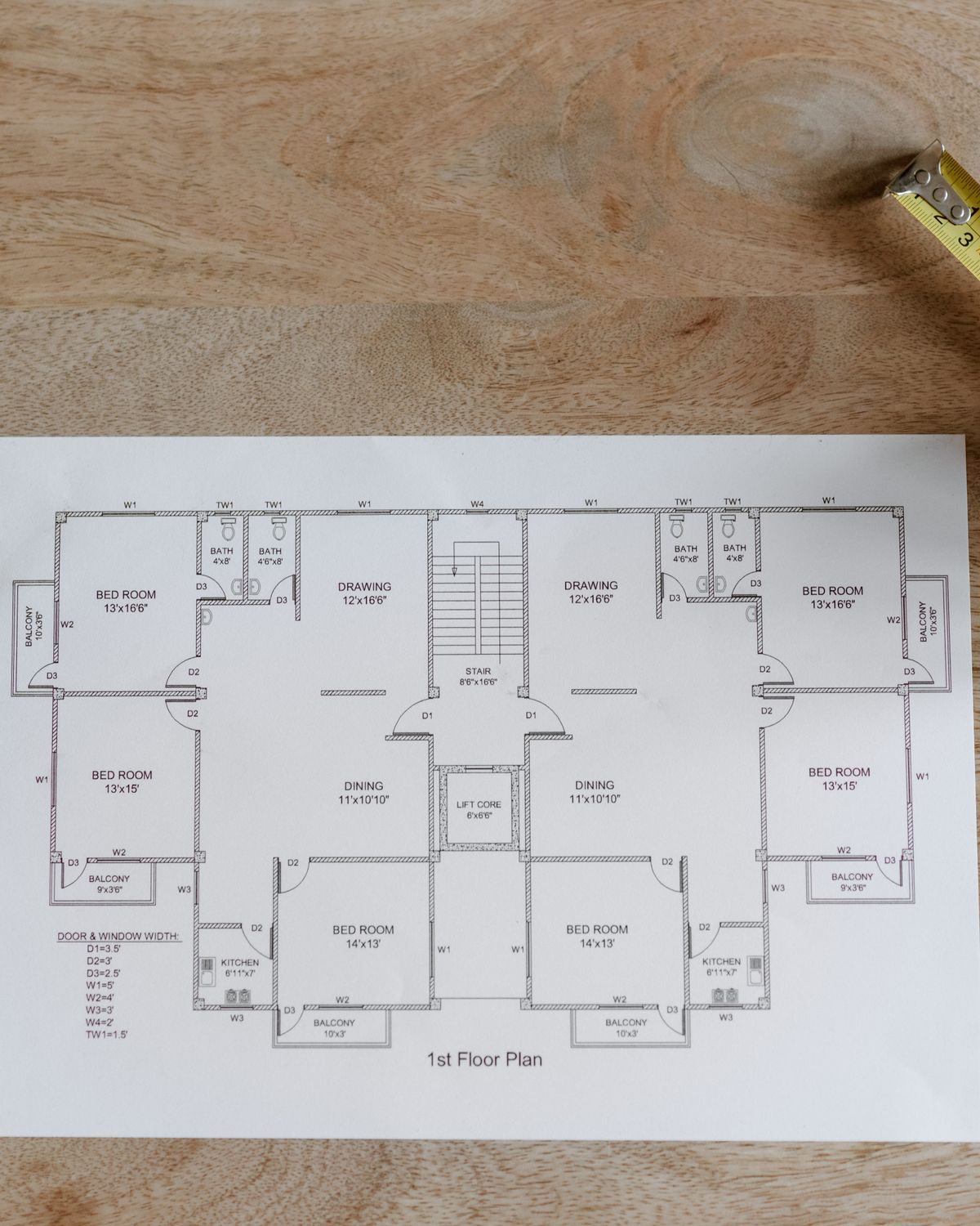 A floor plan laid out on a timber work table